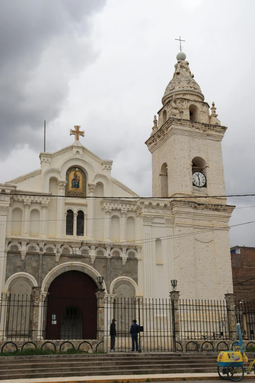 two people are standing in front of an old church