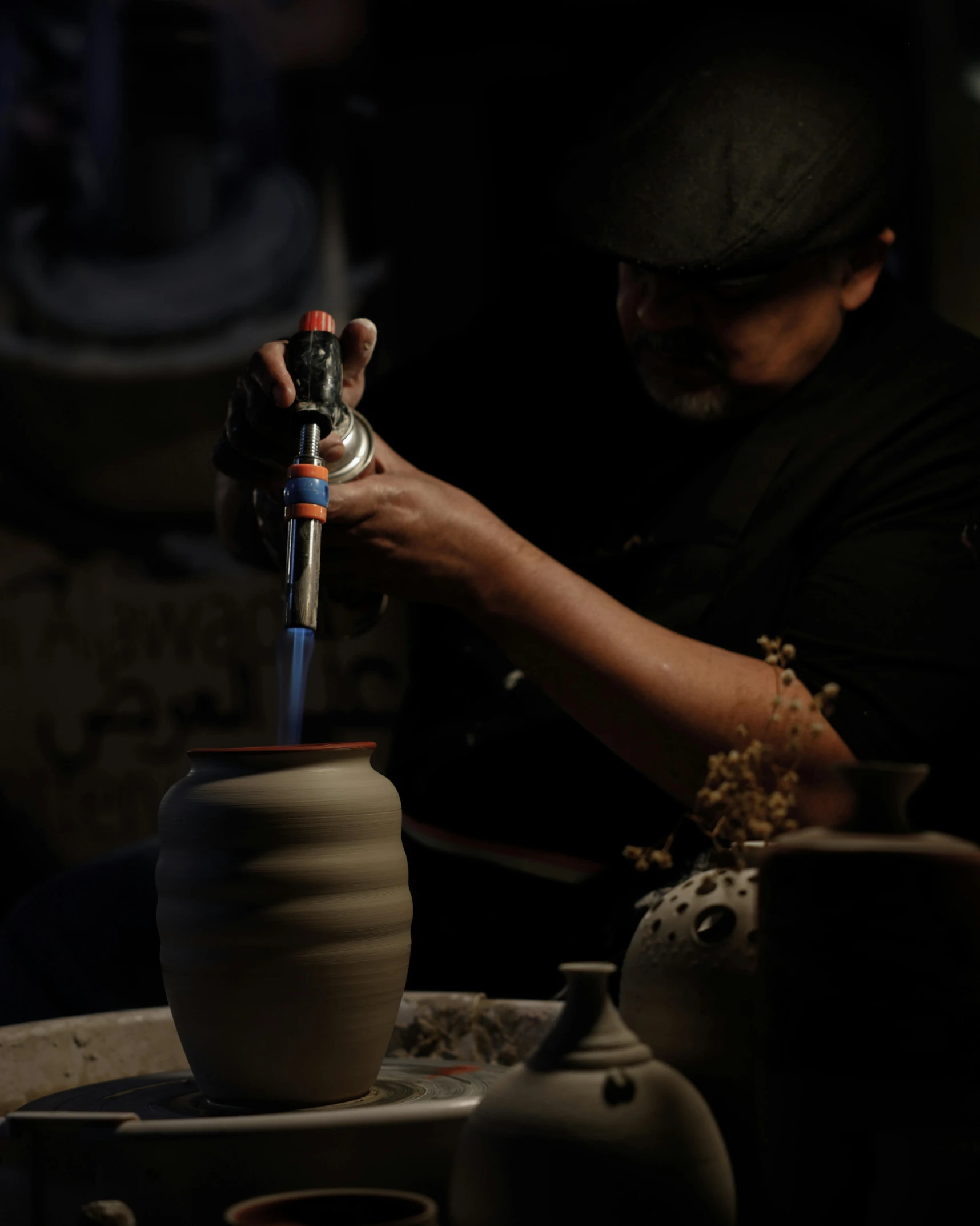 there is a male pottery worker making vases