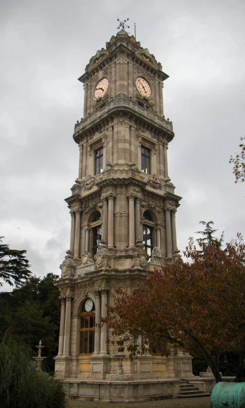 a large clock tower in the middle of a park