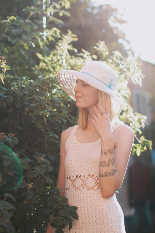 a woman is wearing a white hat and posing for the camera