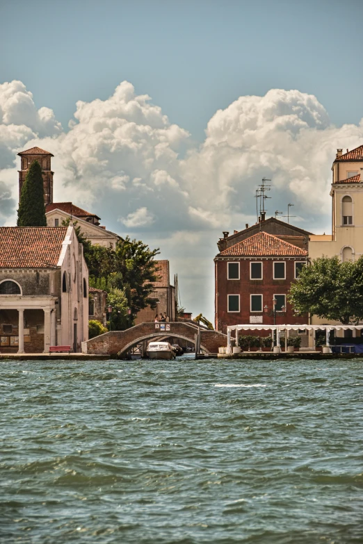 an old brick building with white arches overlooks a canal