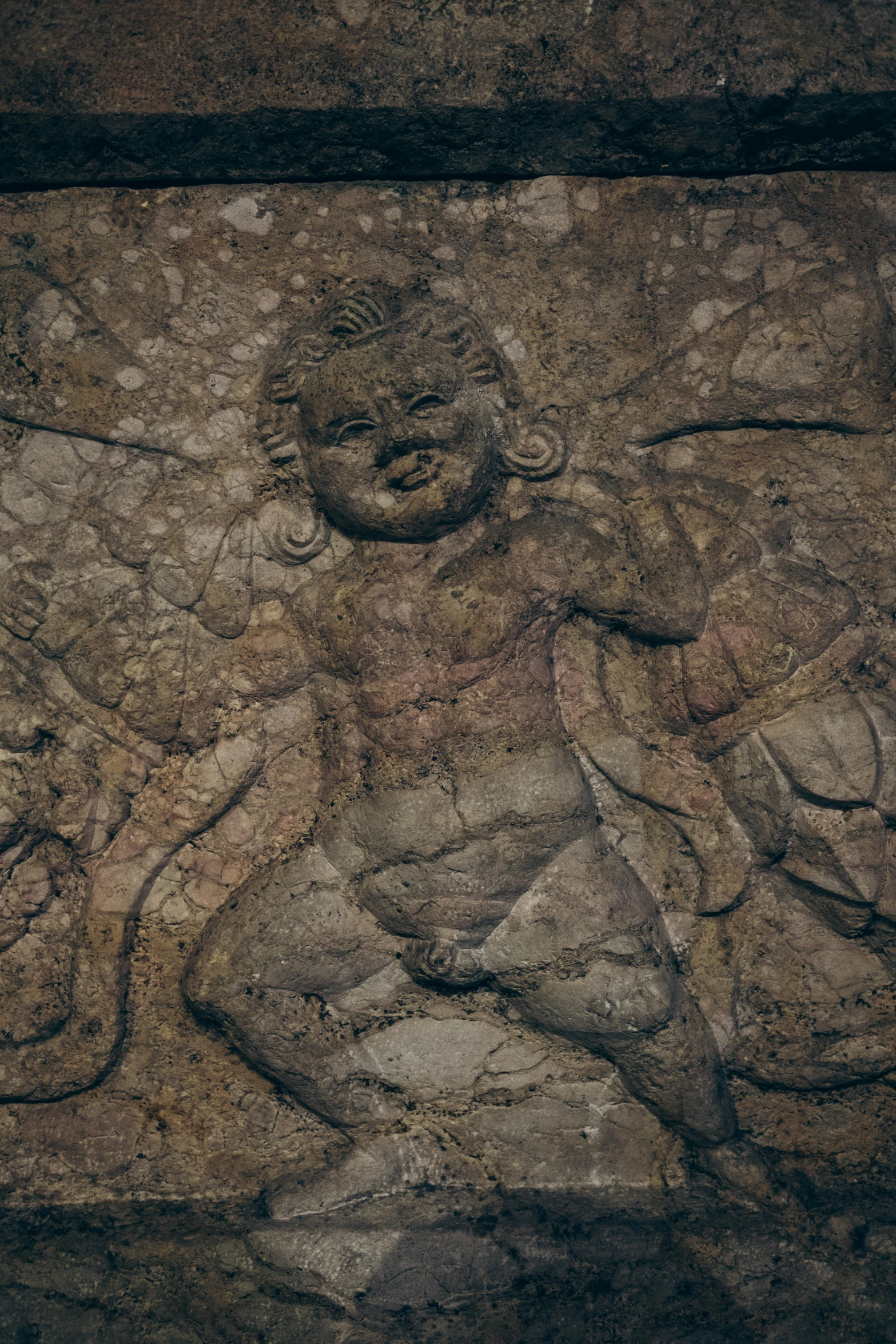 a stone wall with a figure on it's face