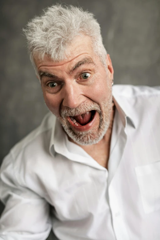 an older man with a surprised look holding soing