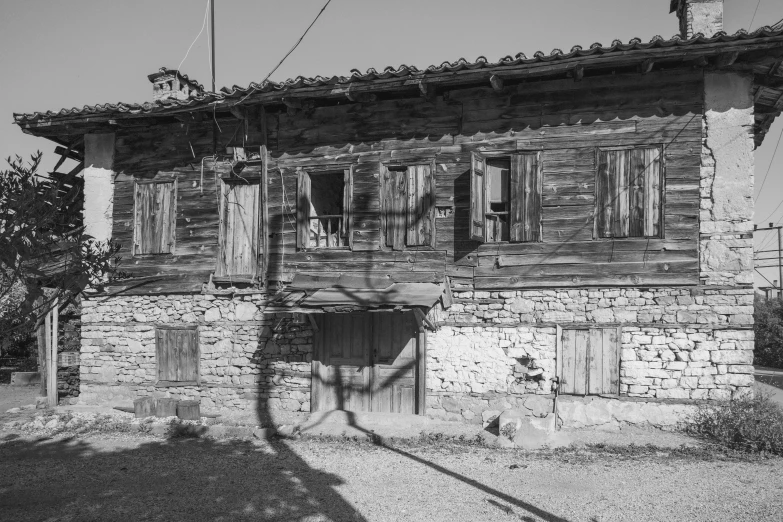 an old house with broken windows sits on the side of the road