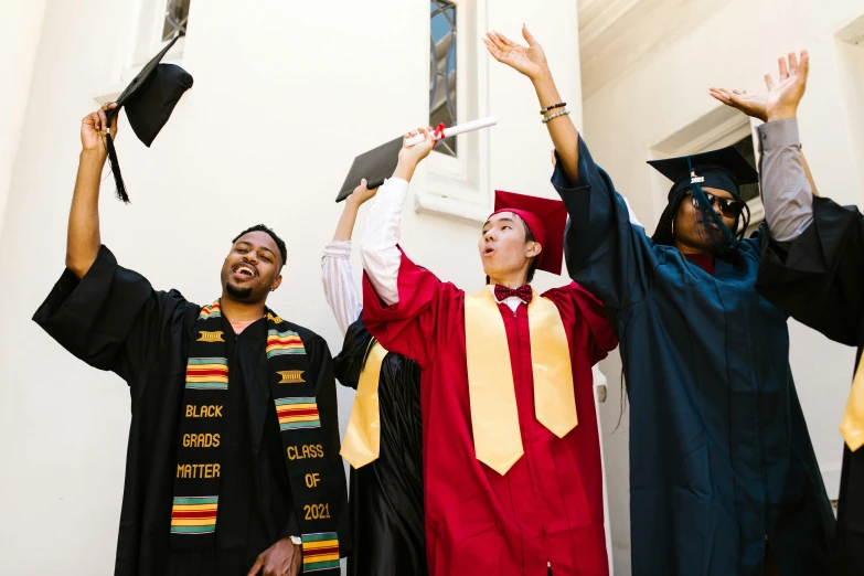 three graduates standing next to each other at graduation