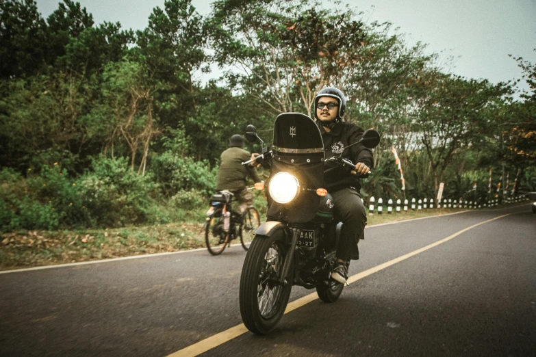 a motorcycle and two people riding bikes down a highway