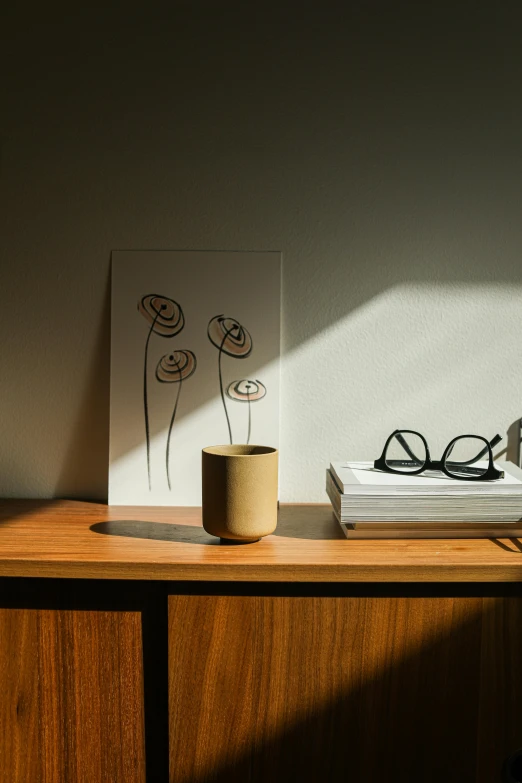 glasses and a vase sitting on top of a wooden cabinet