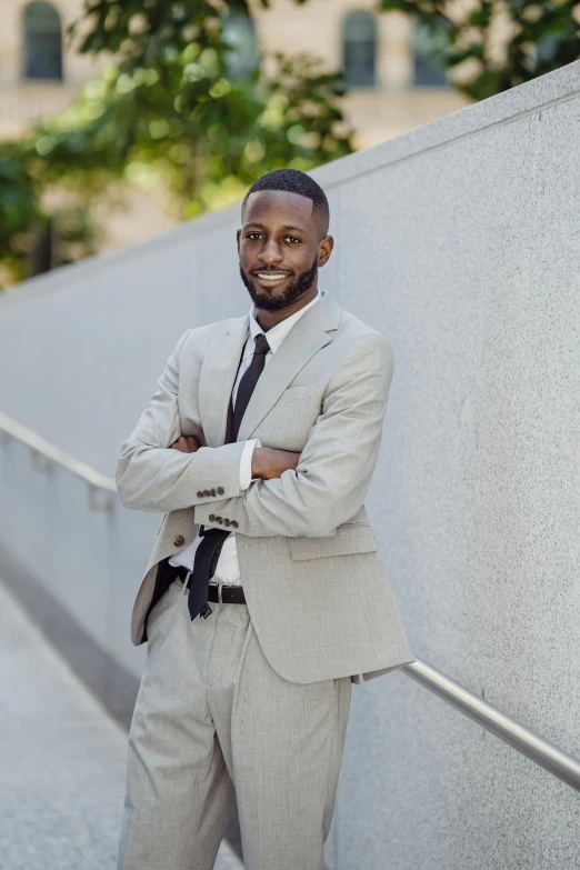 the man in the suit smiles in front of the wall