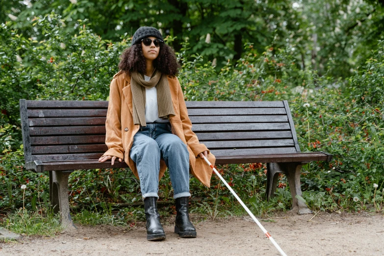 the woman is sitting down on the park bench