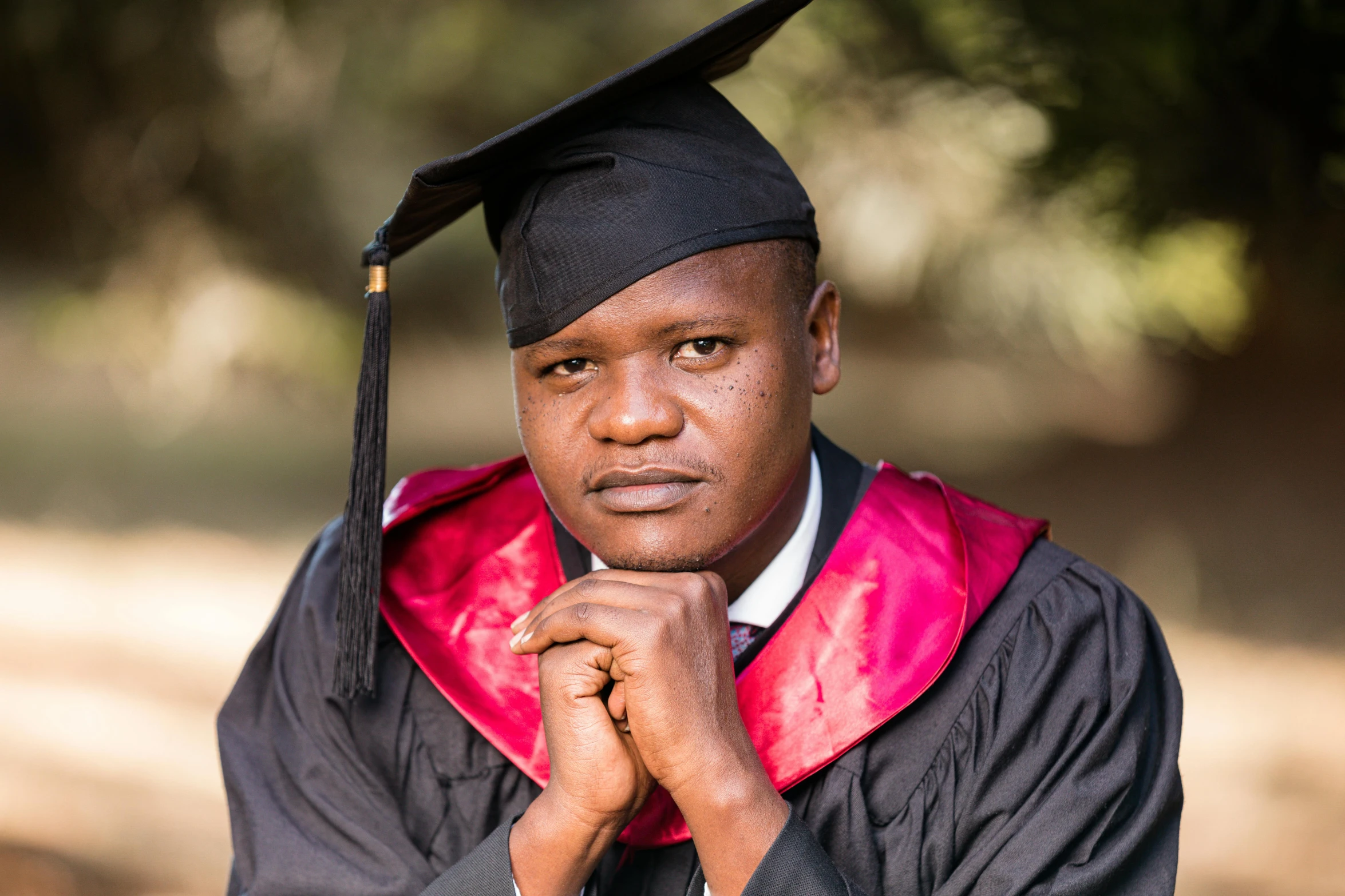 a man in cap and gown holding a finger