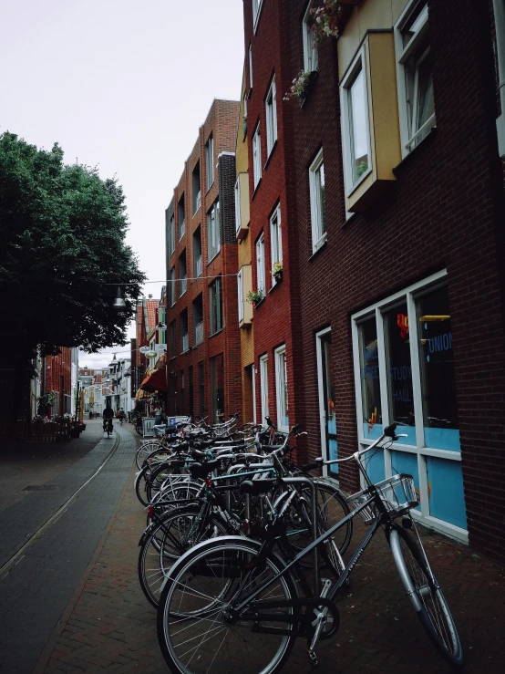 there are many bikes parked on the side of the street