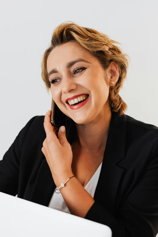 a woman smiles while holding a computer