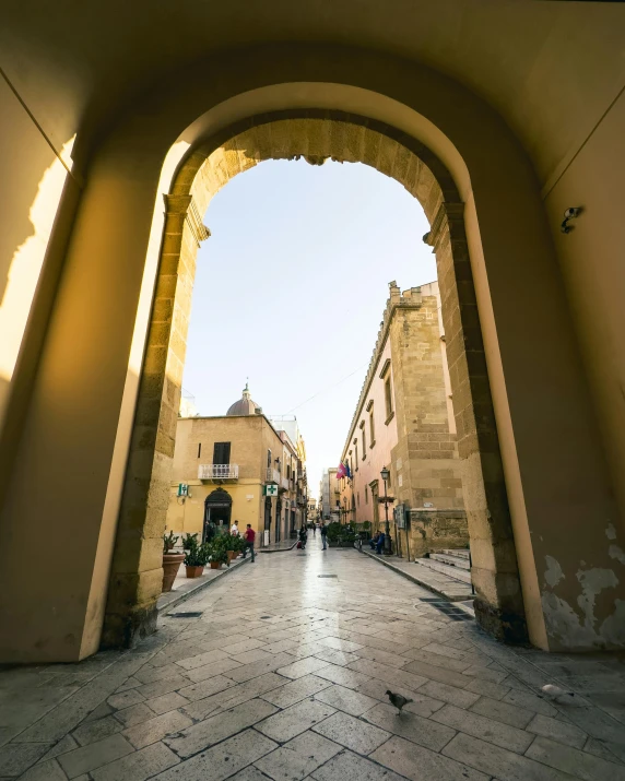 a view through a brick arch looking up at two buildings