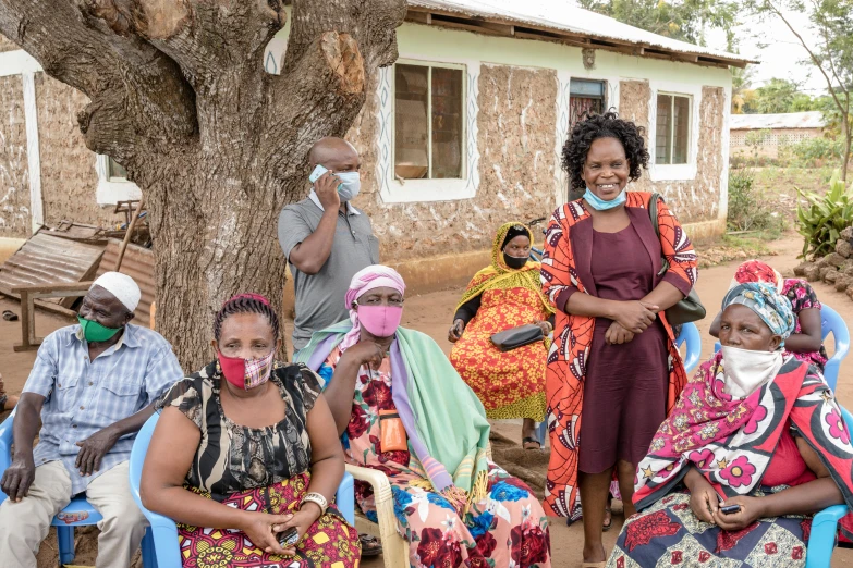 many african americans sit outside a building wearing masks