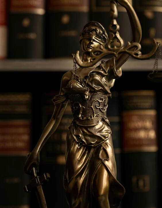 a bronze statue of lady justice holding a staff