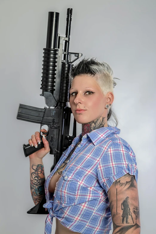 a tattooed woman holding a gun and a machine