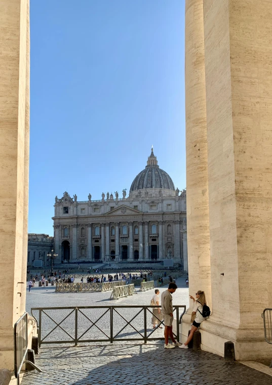 two people look through large pillars at a palace