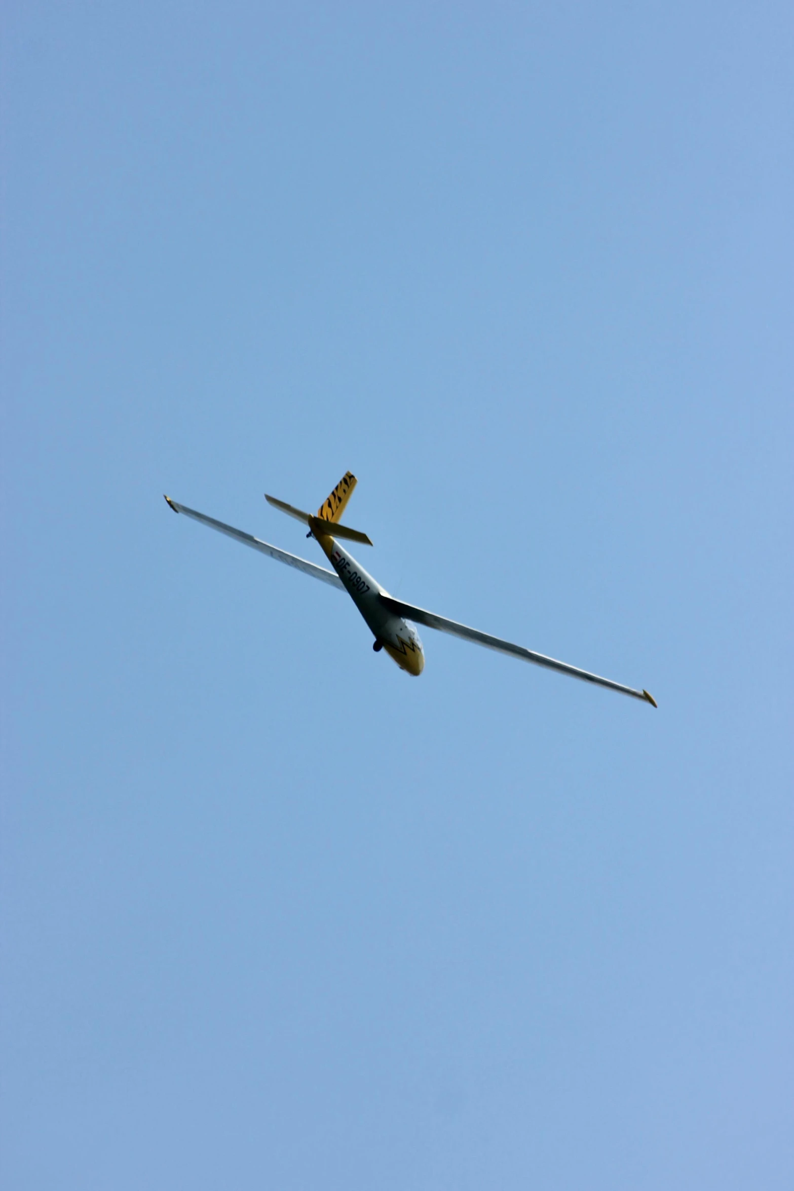 a single airplane flies overhead in a clear sky