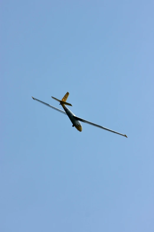 a single airplane flies overhead in a clear sky