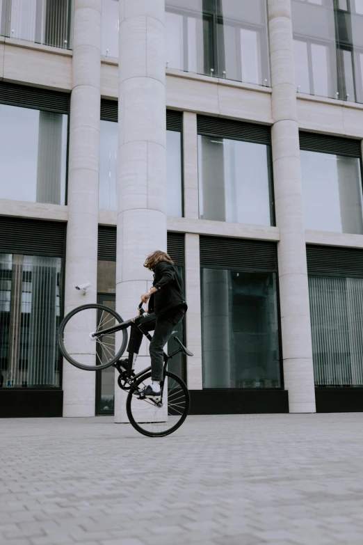 person riding on a bicycle near a building with windows