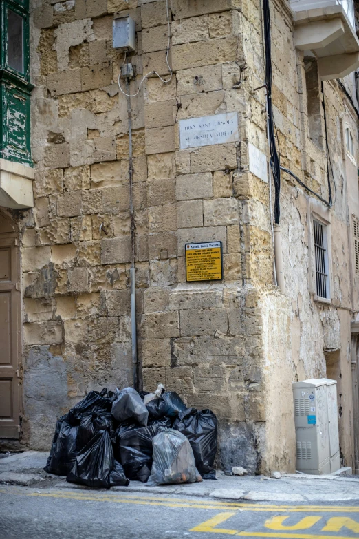 the sign in the stone building indicates the location where a bag is lying on the ground