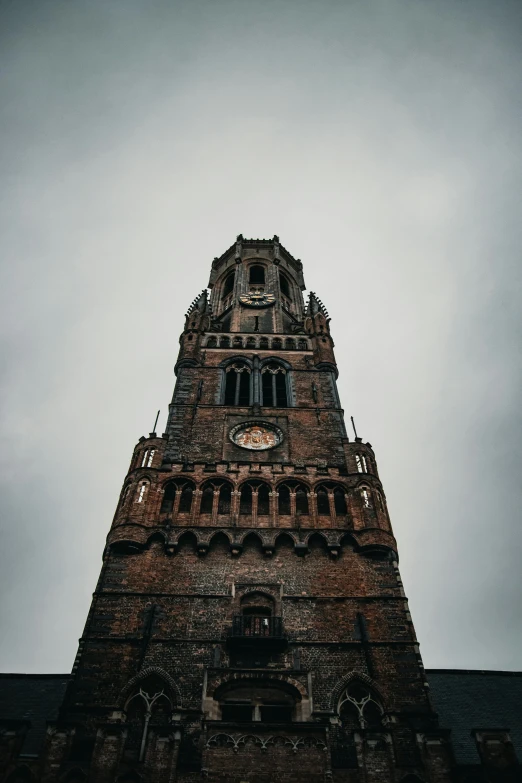 a tall brick building has clocks on it