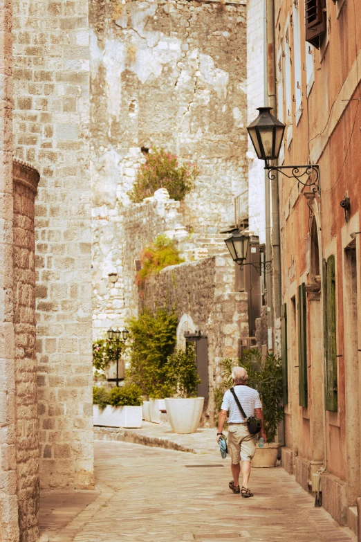 man walking up the street in front of an old building