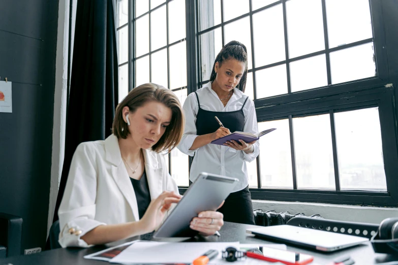 two female employees standing at a table in an office