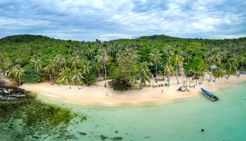 a beach and boats at the shore on a tropical island