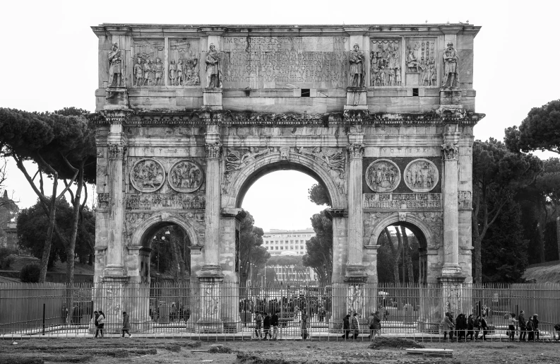 a crowd is gathered around the massive gate