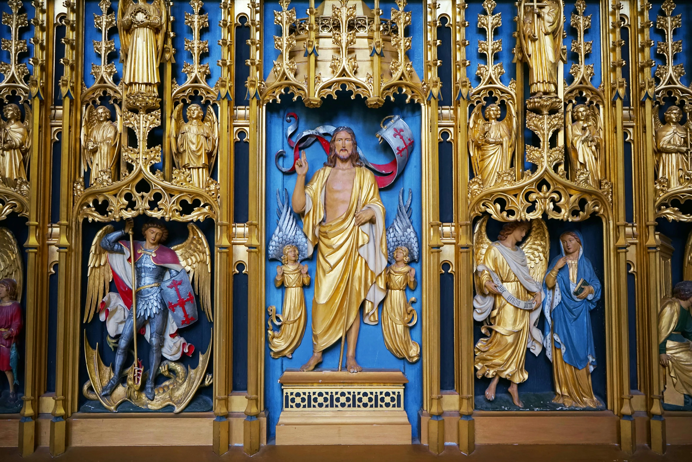 gilded wall panel with sculptures of figures on display