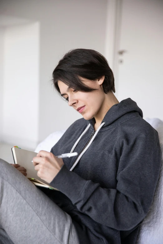 the woman is sitting down and writing