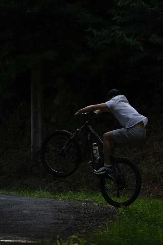 man doing a trick on his bike in the dark