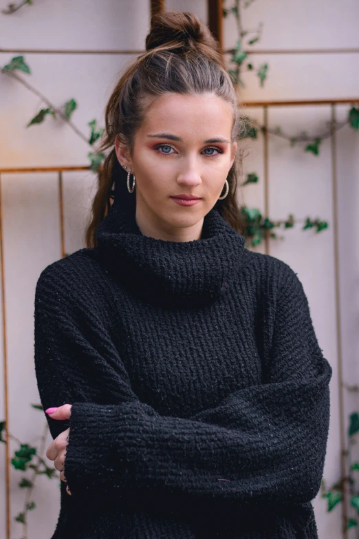 a young woman is wearing an black sweater