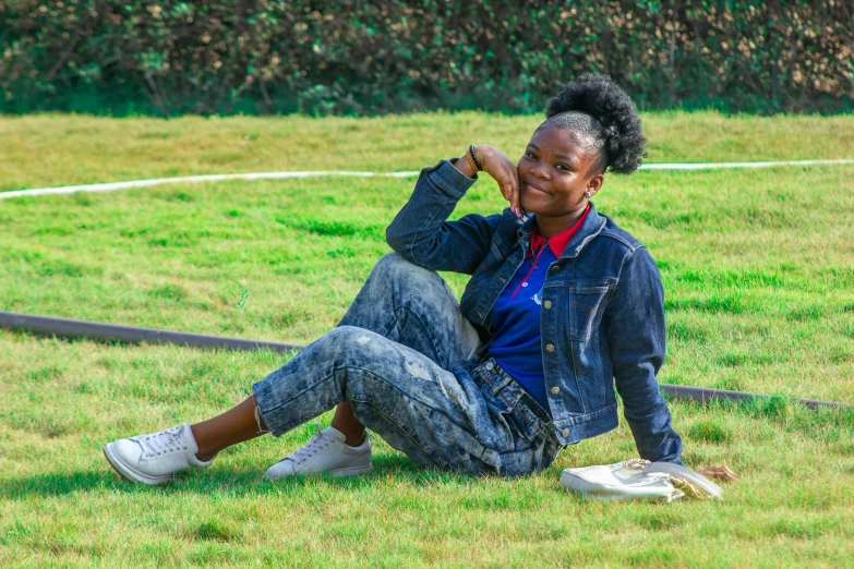 a black woman sitting in the grass with her feet up against her head