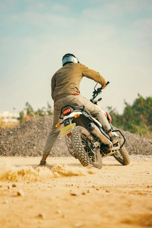 a man in beige clothes on a dirt bike