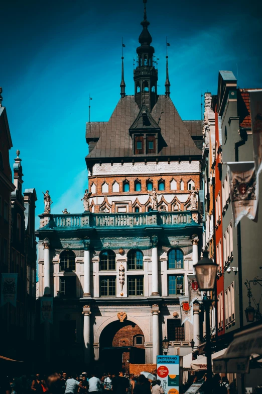 a group of people walking on the street under an old building