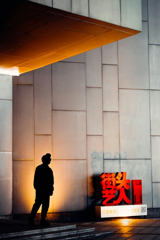 a person is standing near a building with chinese writing