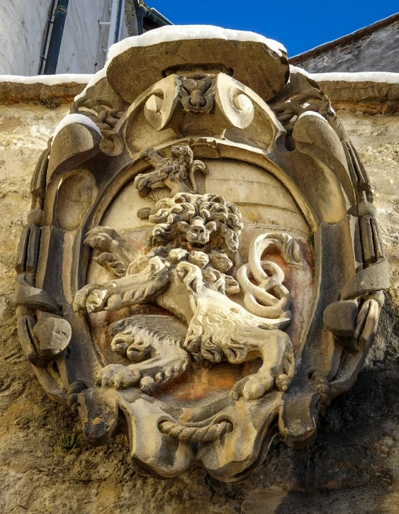 a lion with a dragon in the middle sits on a wall