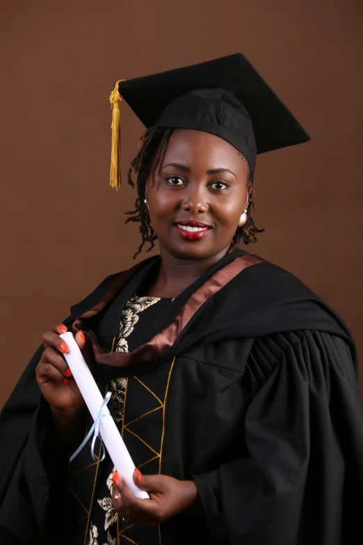 a woman wearing graduation robes and holding her diploma