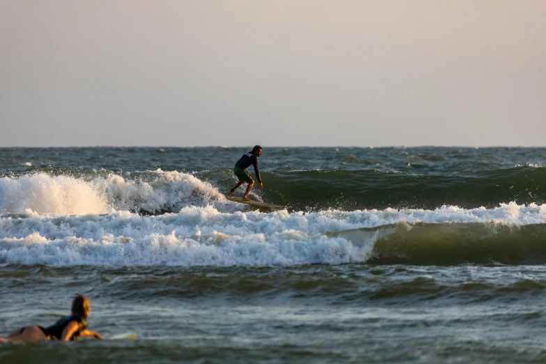 a man riding a wave on top of a surfboard