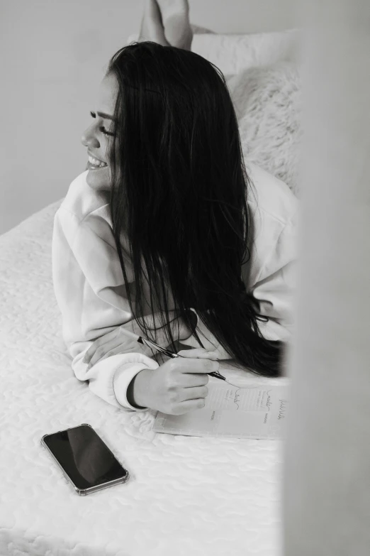 a woman is laying on a bed and looking at a cellphone