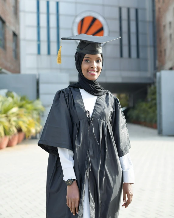 a woman in graduation gown with a basketball on top of her head