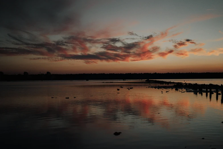 red clouds at dawn over a body of water