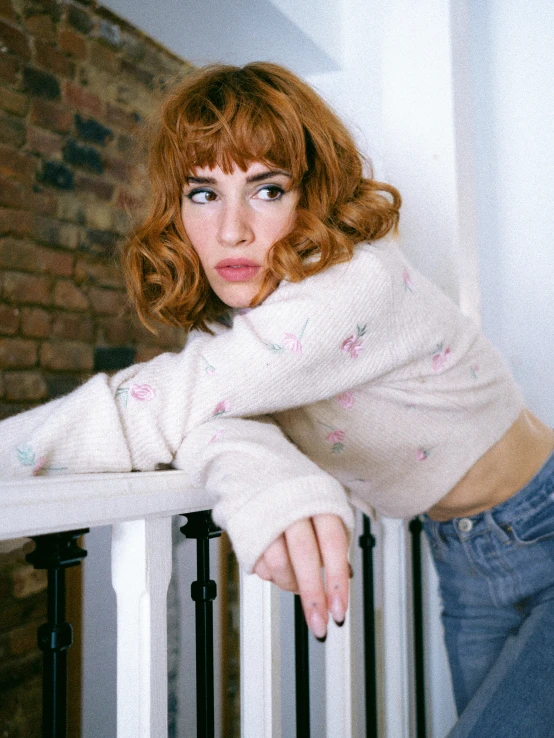 a young woman leans over the rail of a rail