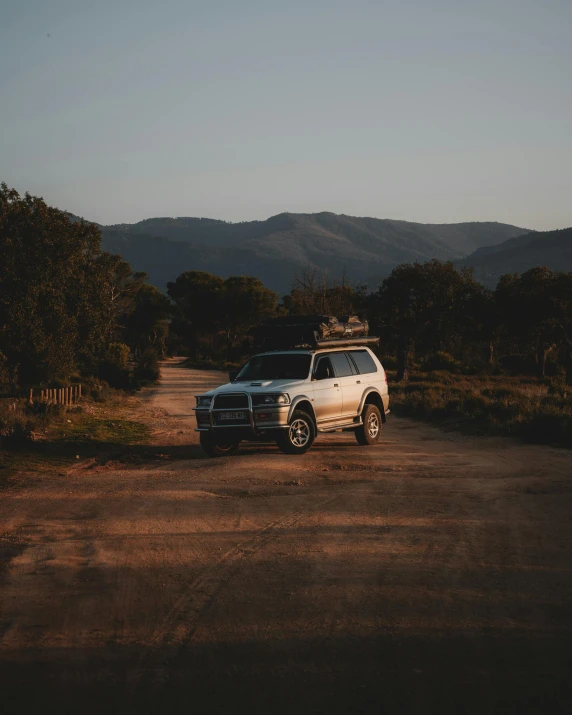 a suv is parked in an area with mountains and trees