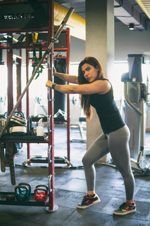 a woman in tights holding a bar