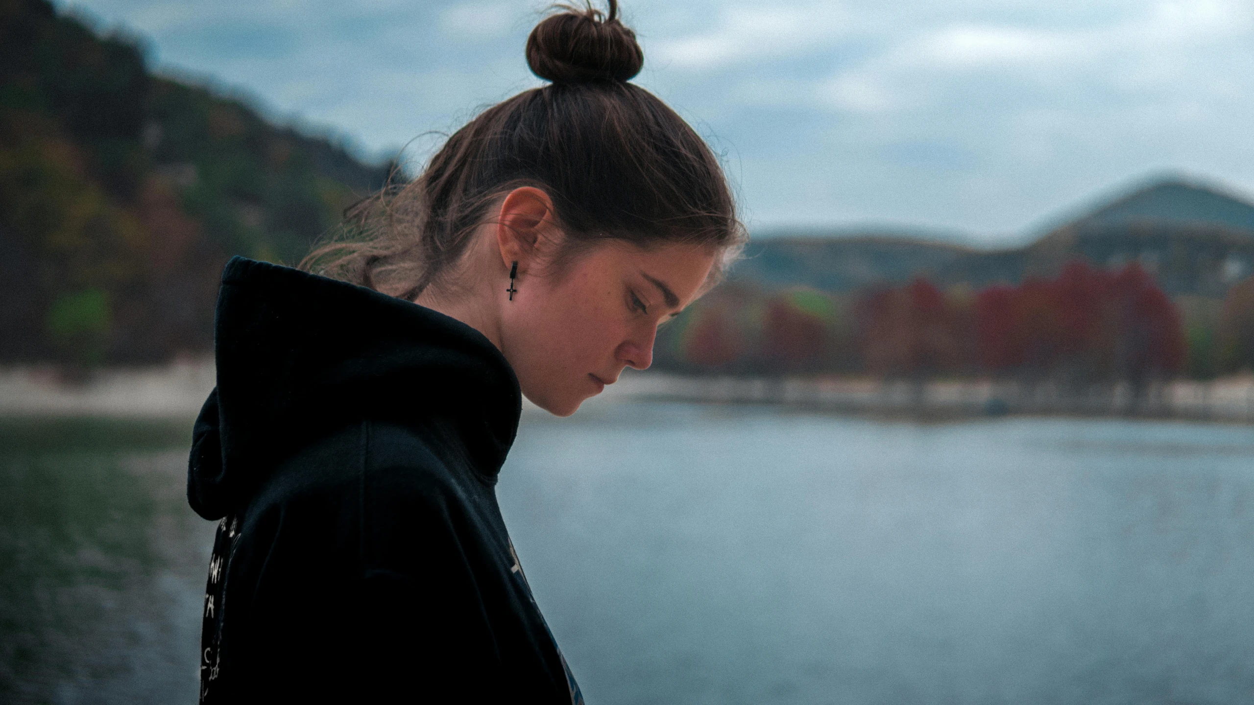 woman wearing a black hoodie, near water