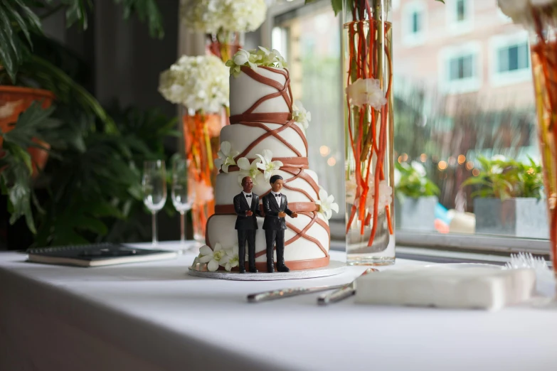 a wedding cake with two people standing next to it