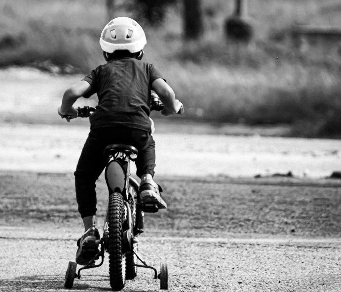 a child riding a bike on dirt road